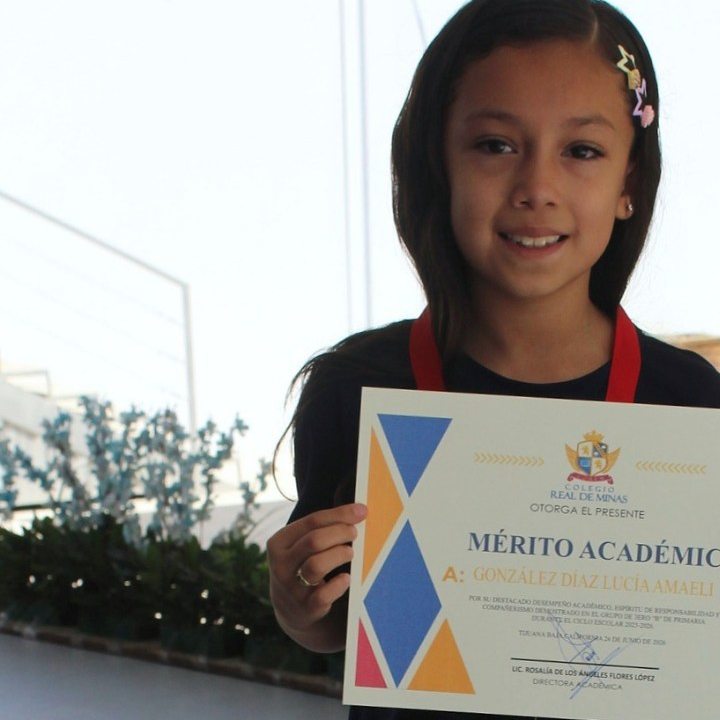 Alumna de Primaria muestra su diploma de mérito académico